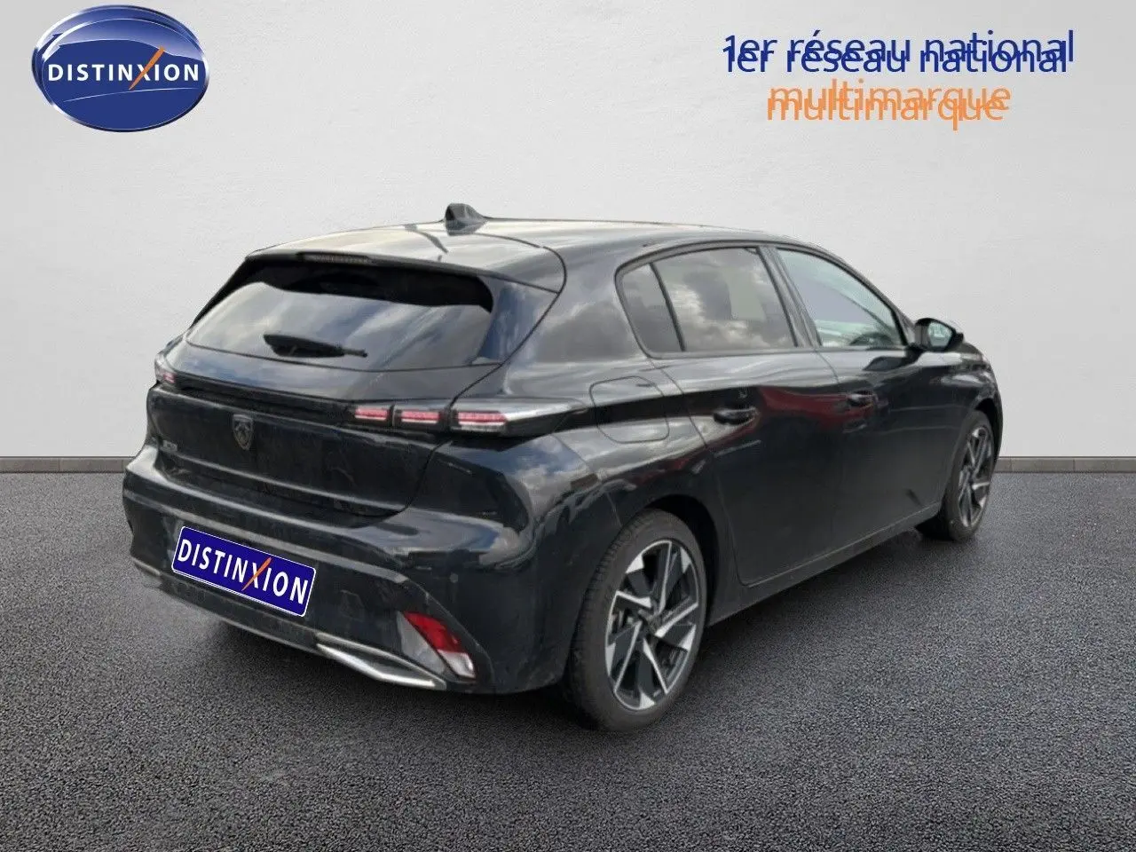 Vue 3/4 arrière droite d'une Peugeot 308 noire métal 2025 avec feux arrière LED et jantes alliage bicolores.