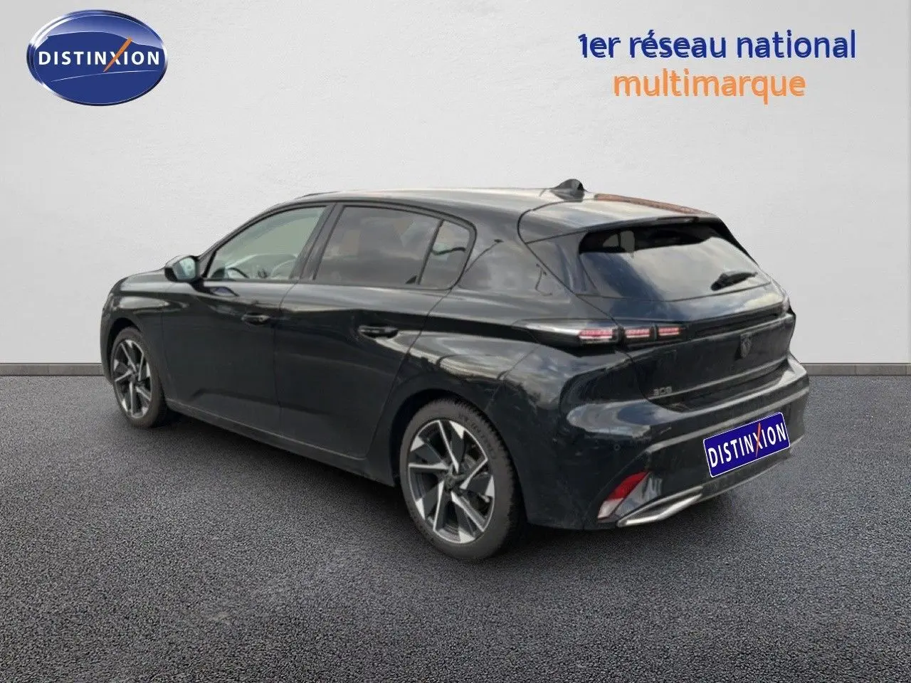 Vue 3/4 arrière droite d'une Peugeot 308 noire métal 2025 avec feux arrière LED et jantes alliage bicolores.