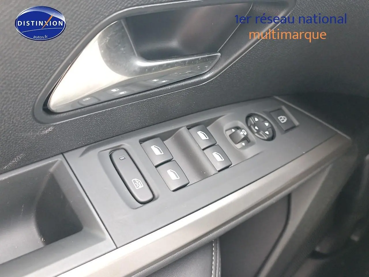 Vue rapprochée des commandes des vitres et rétroviseurs sur la porte avant gauche d’un Peugeot 3008 bleu 2025.