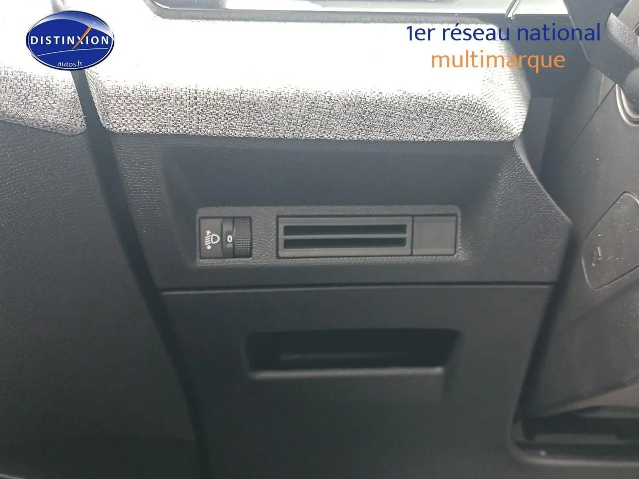 Détail intérieur côté conducteur du Peugeot 3008 bleu 2025, montrant les commandes de réglage des phares et l'aération.