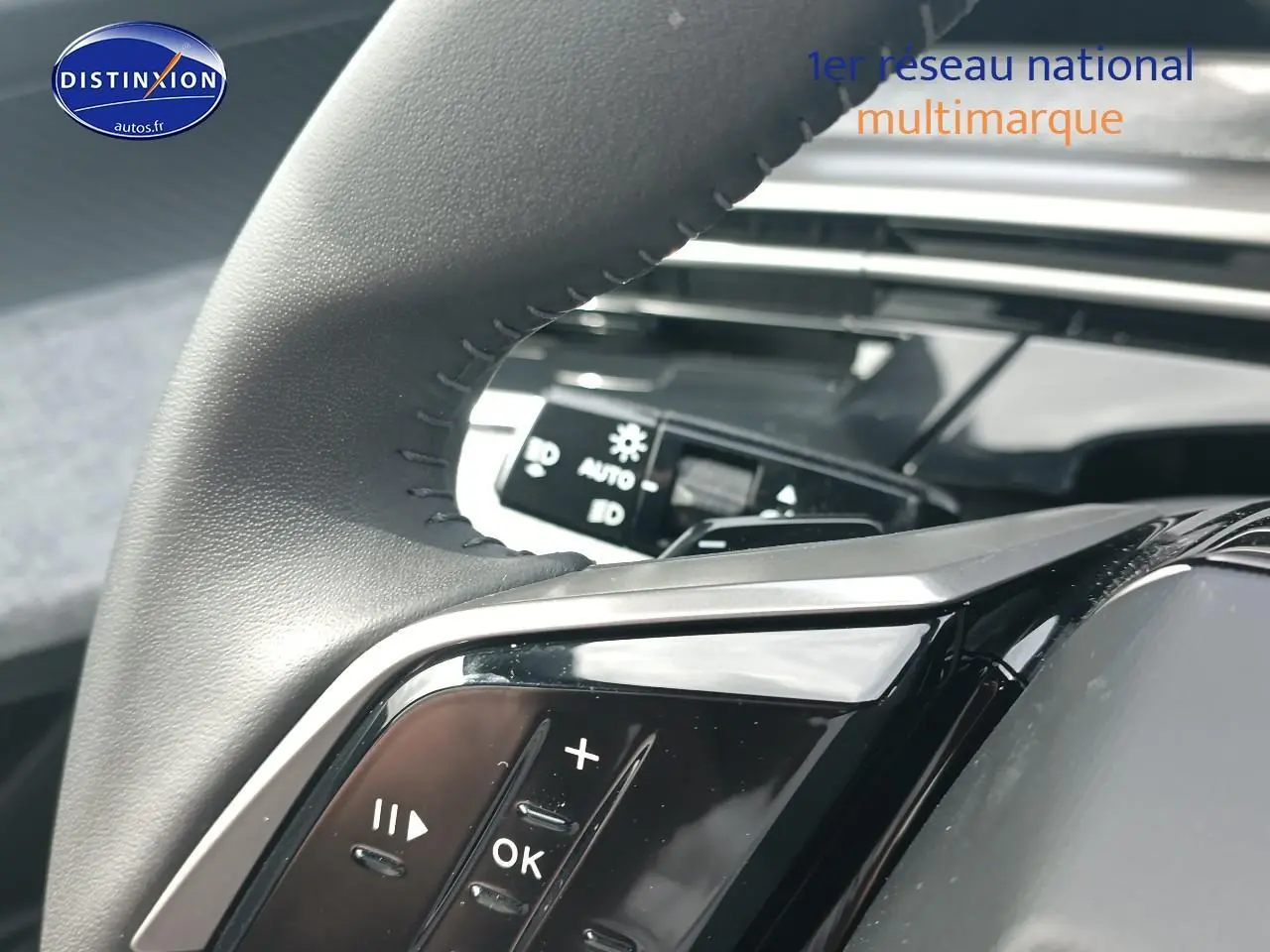 Gros plan sur le volant cuir multifonction côté gauche du Peugeot 3008 bleu, avec commandes audio visibles.