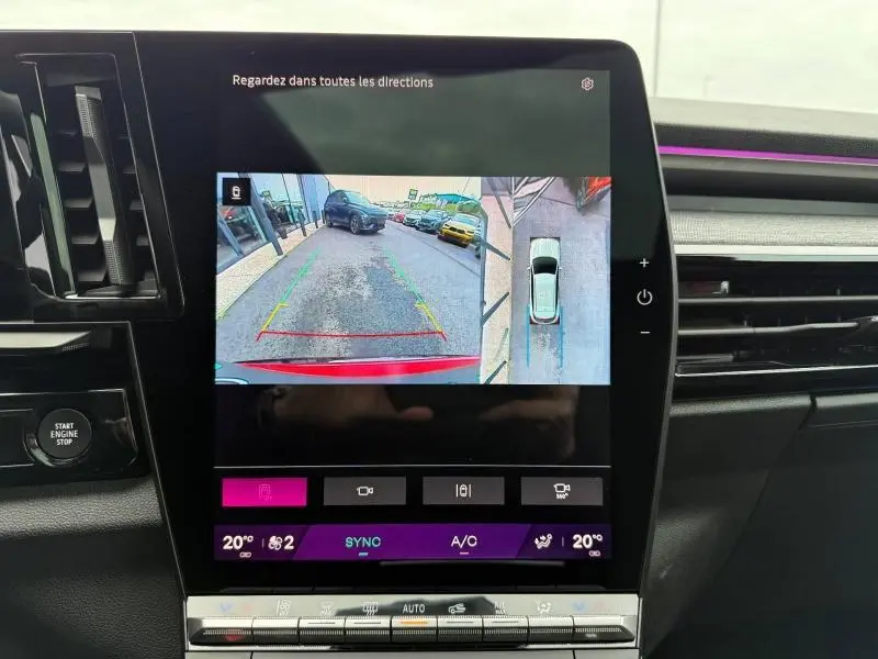 Écran central affichant la caméra de recul et vue 360° du Renault Austral rouge flamme, intérieur avec tableau de bord moderne.