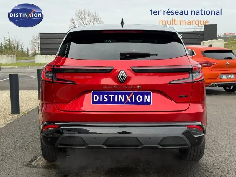 Vue arrière du Renault Austral 2025 rouge flamme avec feux LED horizontaux et logo centré sur un parking.
