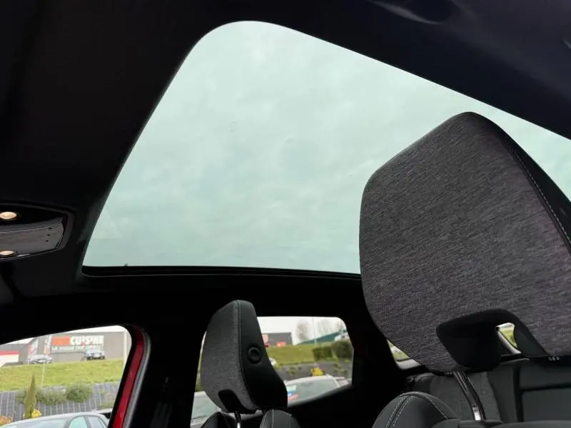 Vue intérieure du Renault Austral rouge flamme 2025, mettant en valeur le toit panoramique et les appuie-têtes avant.