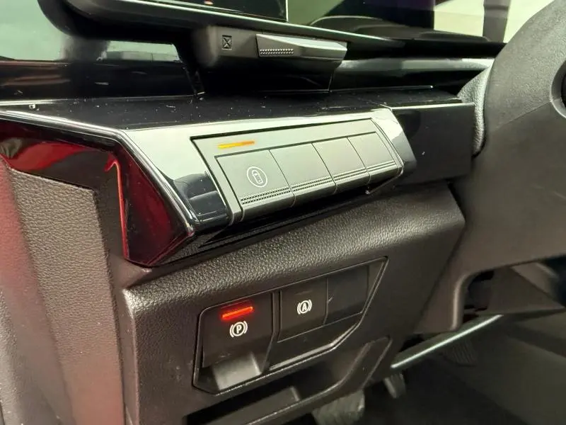 Détail intérieur côté gauche du tableau de bord du Renault Austral 2025, boutons de verrouillage et frein à main électronique.