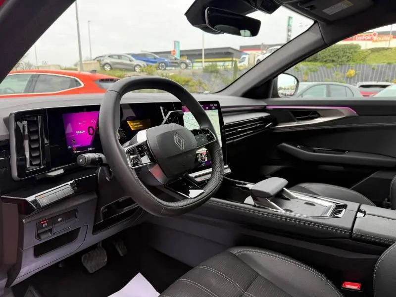 Vue intérieure côté conducteur du Renault Austral 2025 hybride, avec tableau de bord numérique et ambiance lumineuse violette.