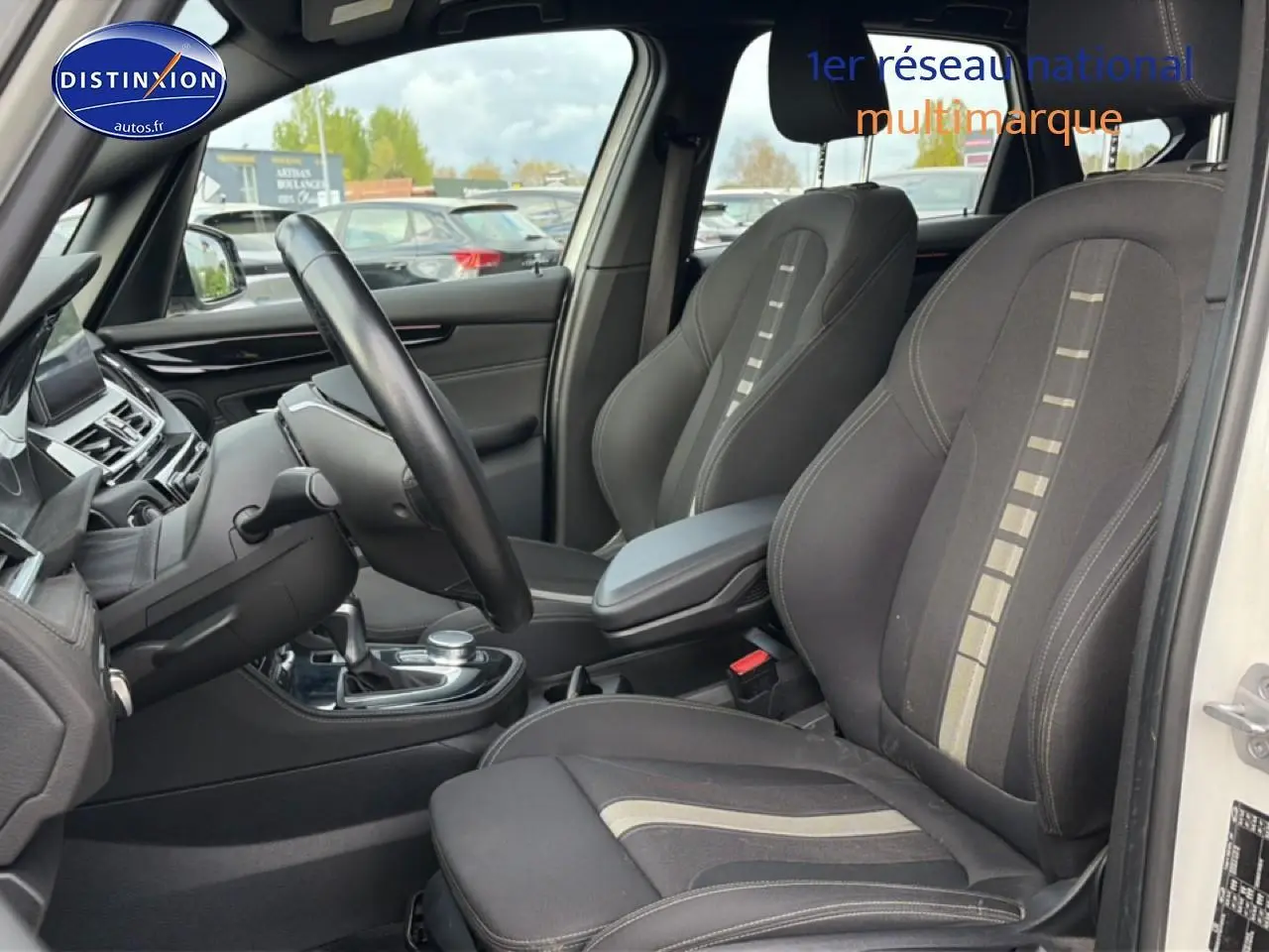 Vue intérieure côté conducteur de la BMW Série 2 Active Tourer (f45) avec sièges tissu anthracite et accoudoir central.
