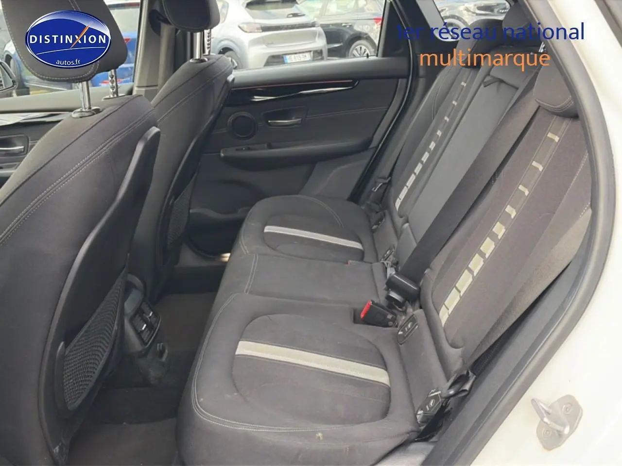 Vue intérieure côté droit montrant la banquette arrière en tissu anthracite avec bandes claires d'une BMW Série 2 Active Tourer gris argent.