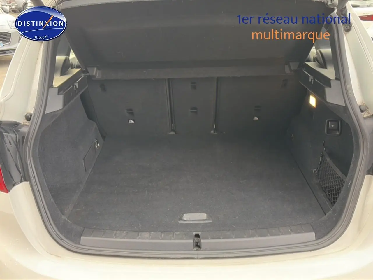 Coffre ouvert vu de l'arrière d'une BMW Série 2 Active Tourer gris argent, espace de chargement spacieux et propre.