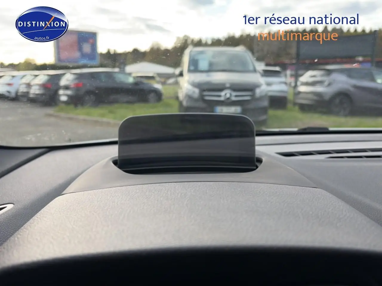 Affichage tête haute déployé sur le tableau de bord gris d'une BMW Série 2 Active Tourer, vue depuis le siège conducteur.
