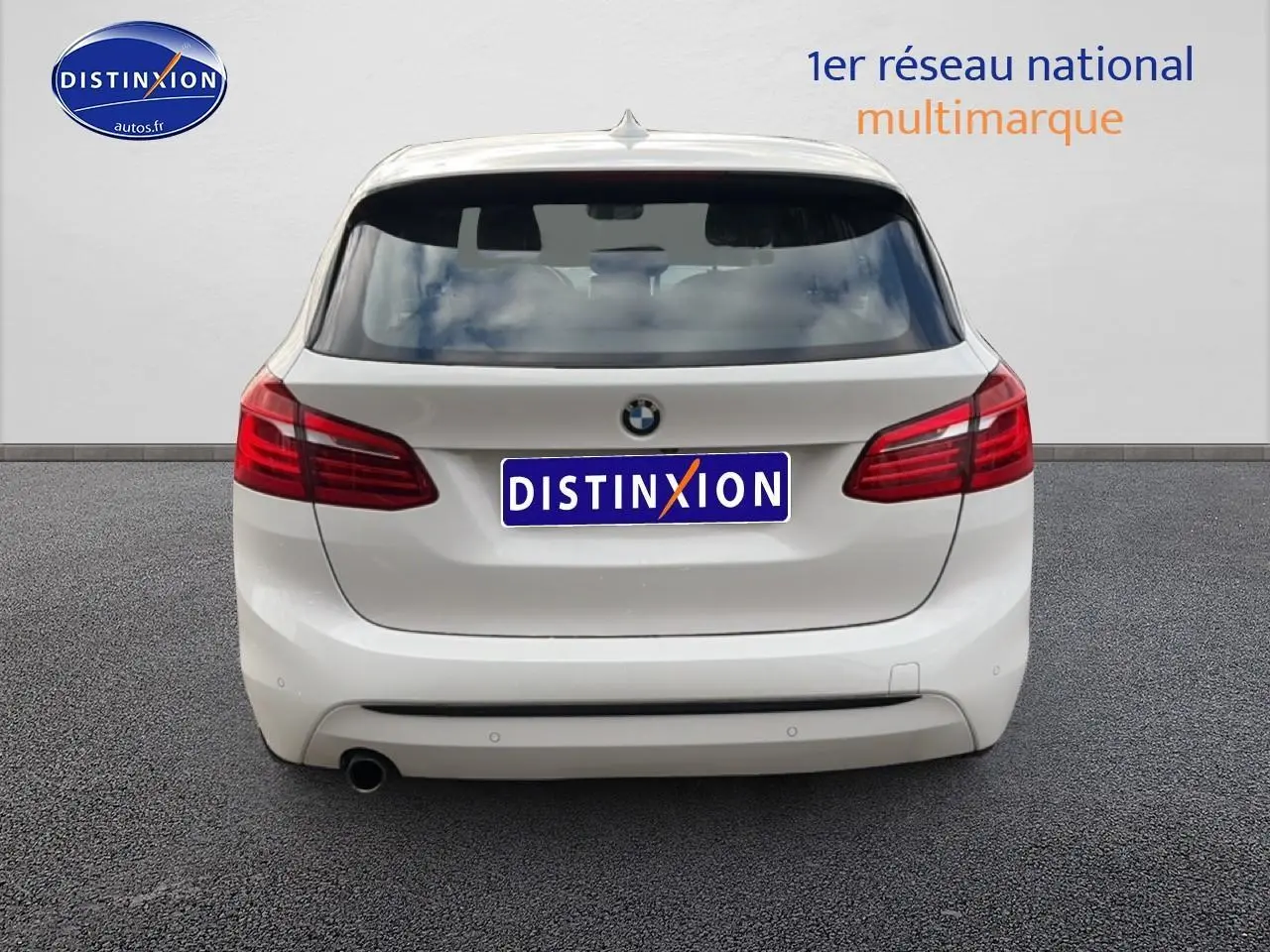 Vue arrière d'une BMW Série 2 Active Tourer gris argent avec feux rouges et sortie d'échappement chromée.