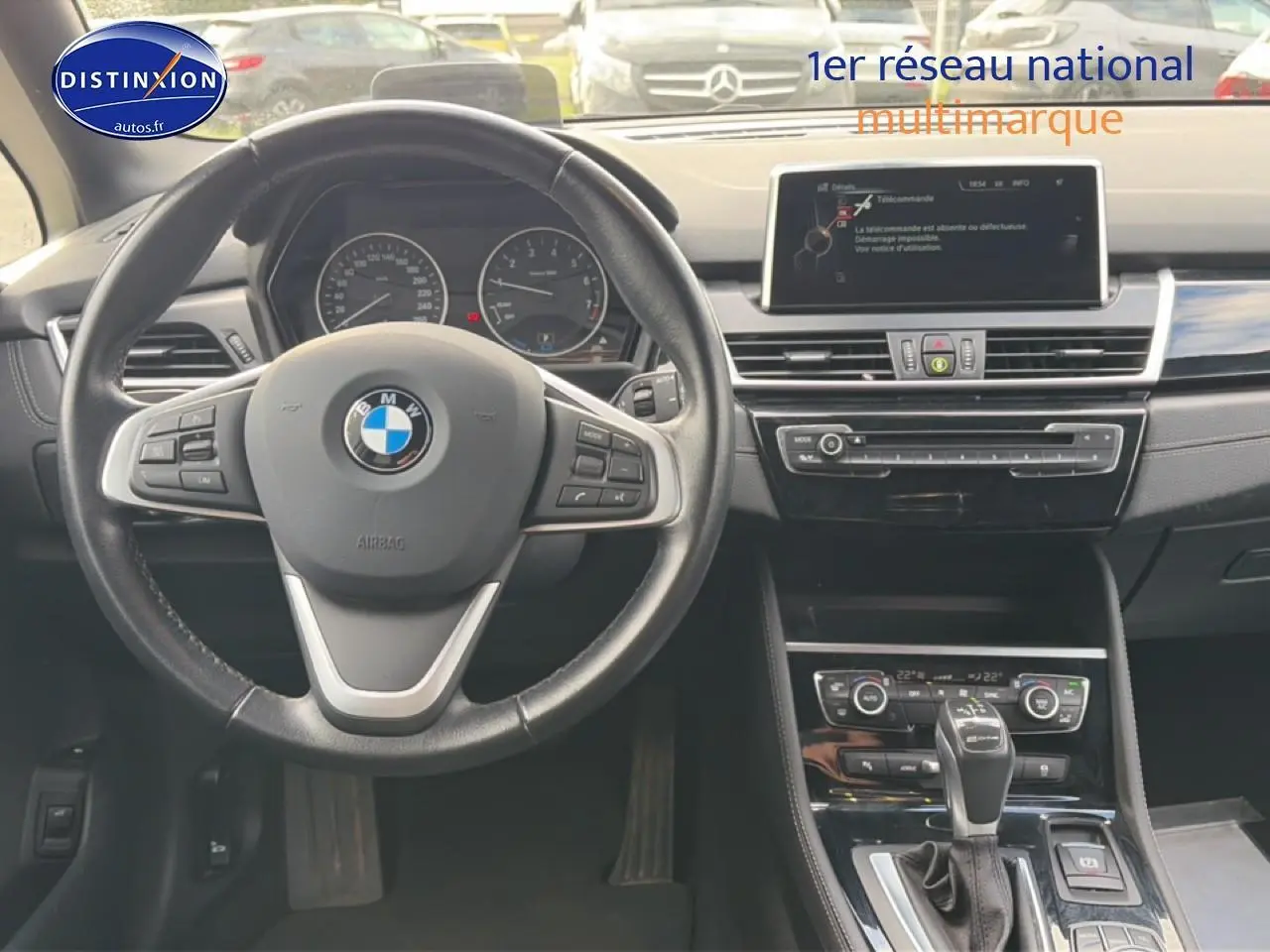 Vue intérieure centrée sur le volant cuir multifonction et la console centrale d'une BMW Série 2 Active Tourer gris argent.