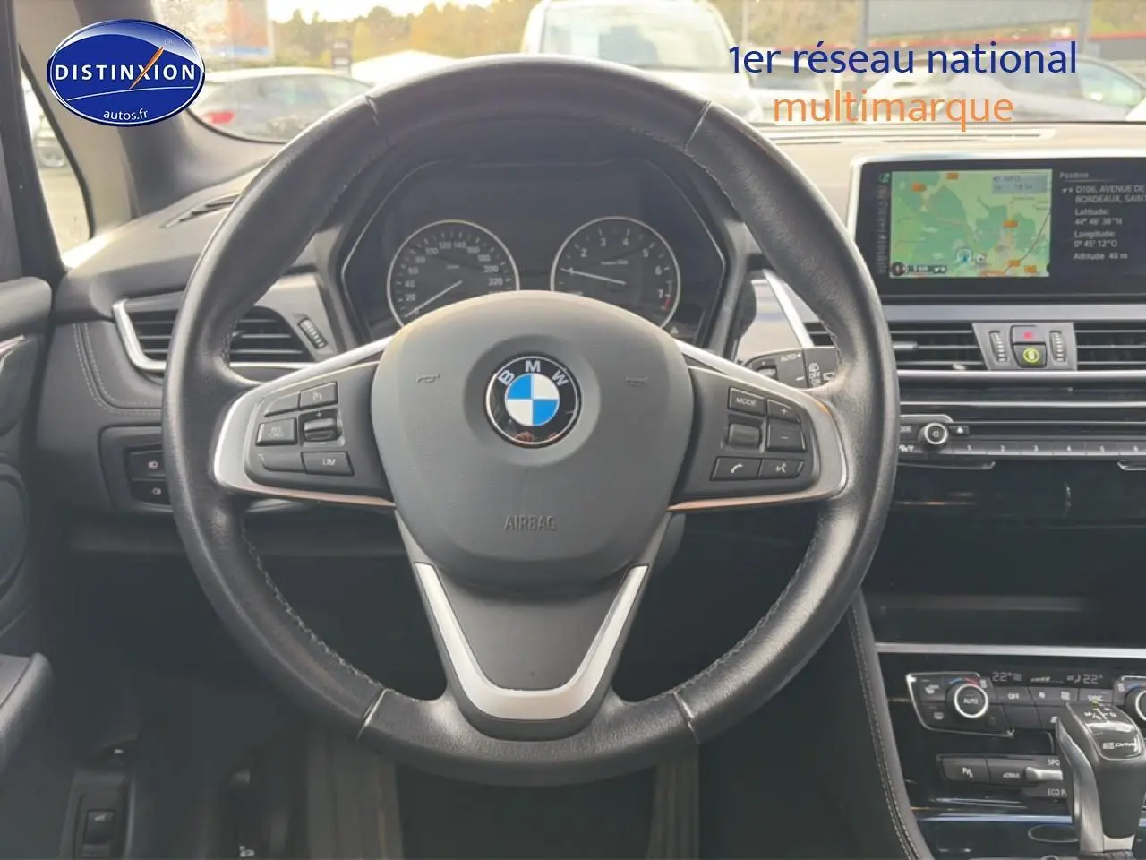 Vue centrée sur le volant cuir multifonction noir de la BMW Série 2 Active Tourer avec tableau de bord et écran GPS.