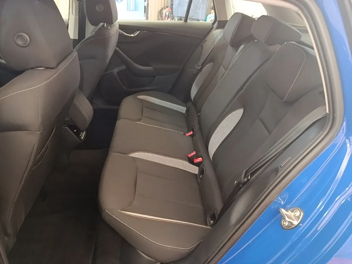 Vue intérieure côté droit des sièges arrière noirs avec inserts gris d'une Skoda Scala bleu 2024.
