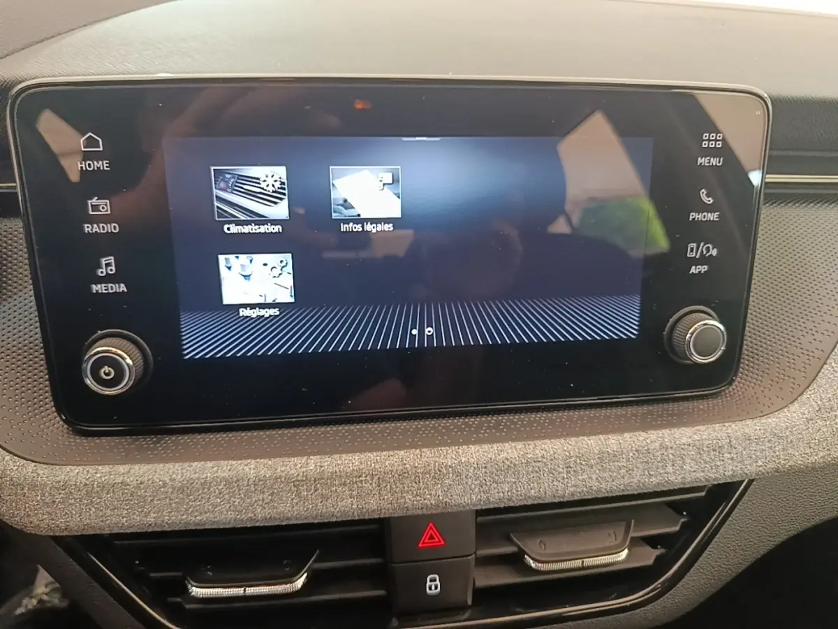 Écran tactile central du tableau de bord de la Skoda Scala 2024 avec commandes climatisation et médias visibles.