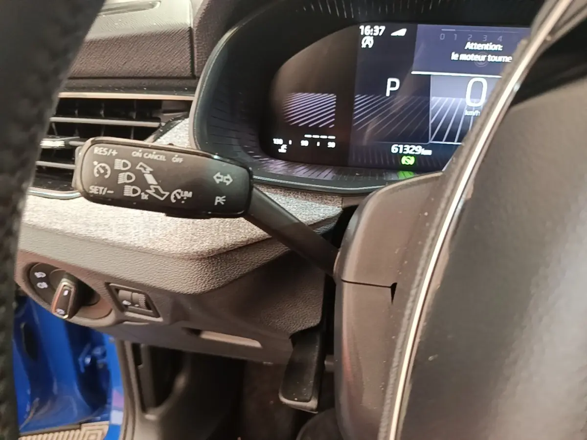 Vue rapprochée du tableau de bord et du volant du Skoda Scala bleu, avec affichage digital et commandes au volant visibles.