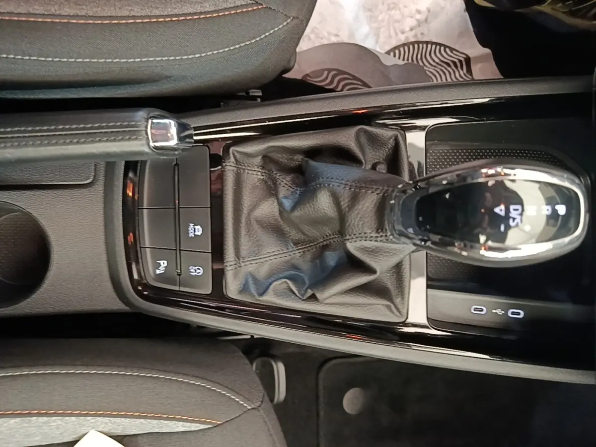 Vue plongeante sur la console centrale de la Skoda Scala 1.5 TSI 2024, avec levier de vitesse DSG7 et frein à main cuir.