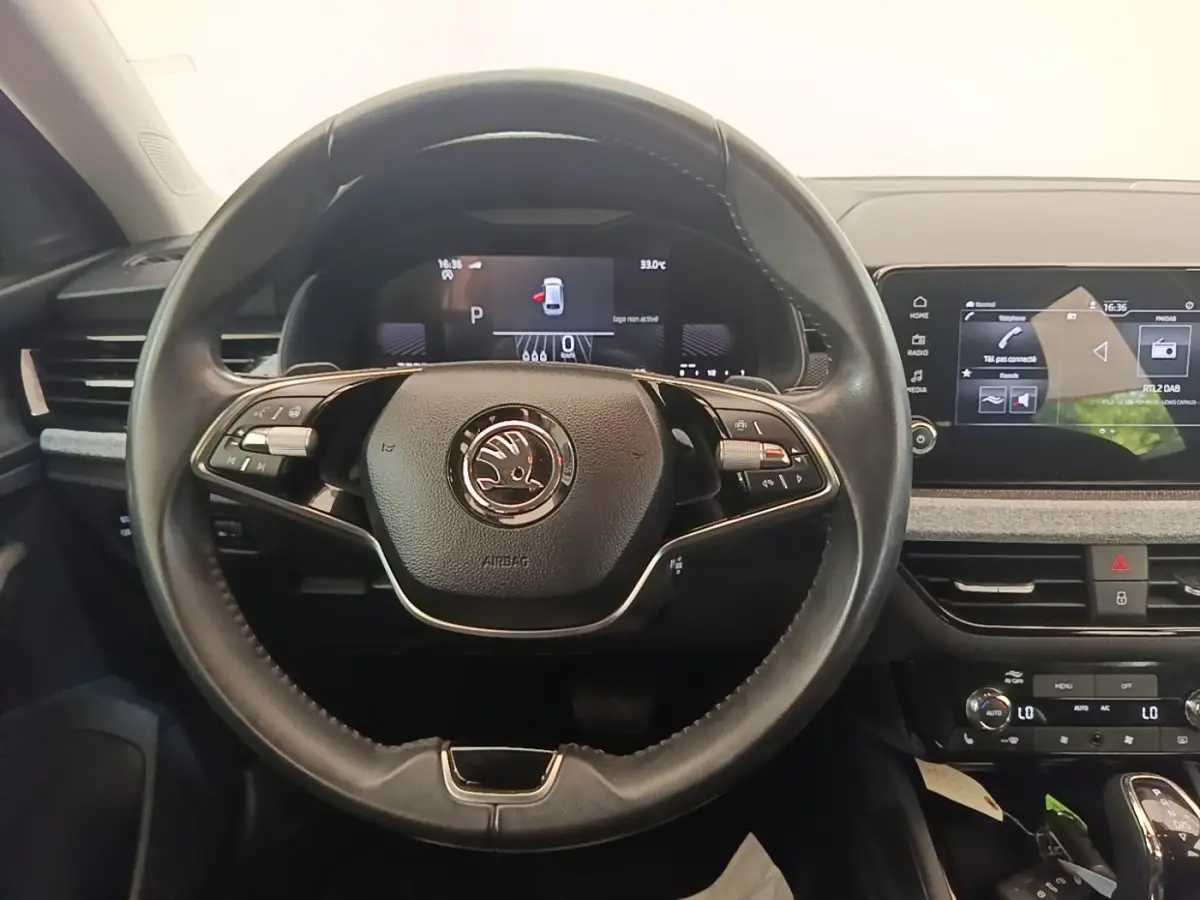 Vue intérieure centrée sur le volant cuir et alu multifonctions d'une Skoda Scala 2024 avec tableau de bord digital.