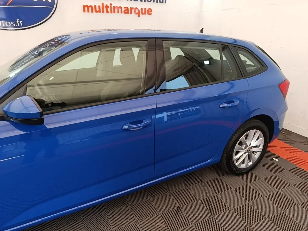 Vue de profil côté gauche d’une Skoda Scala 2024 bleu, avec jantes alliage et rétroviseurs assortis.
