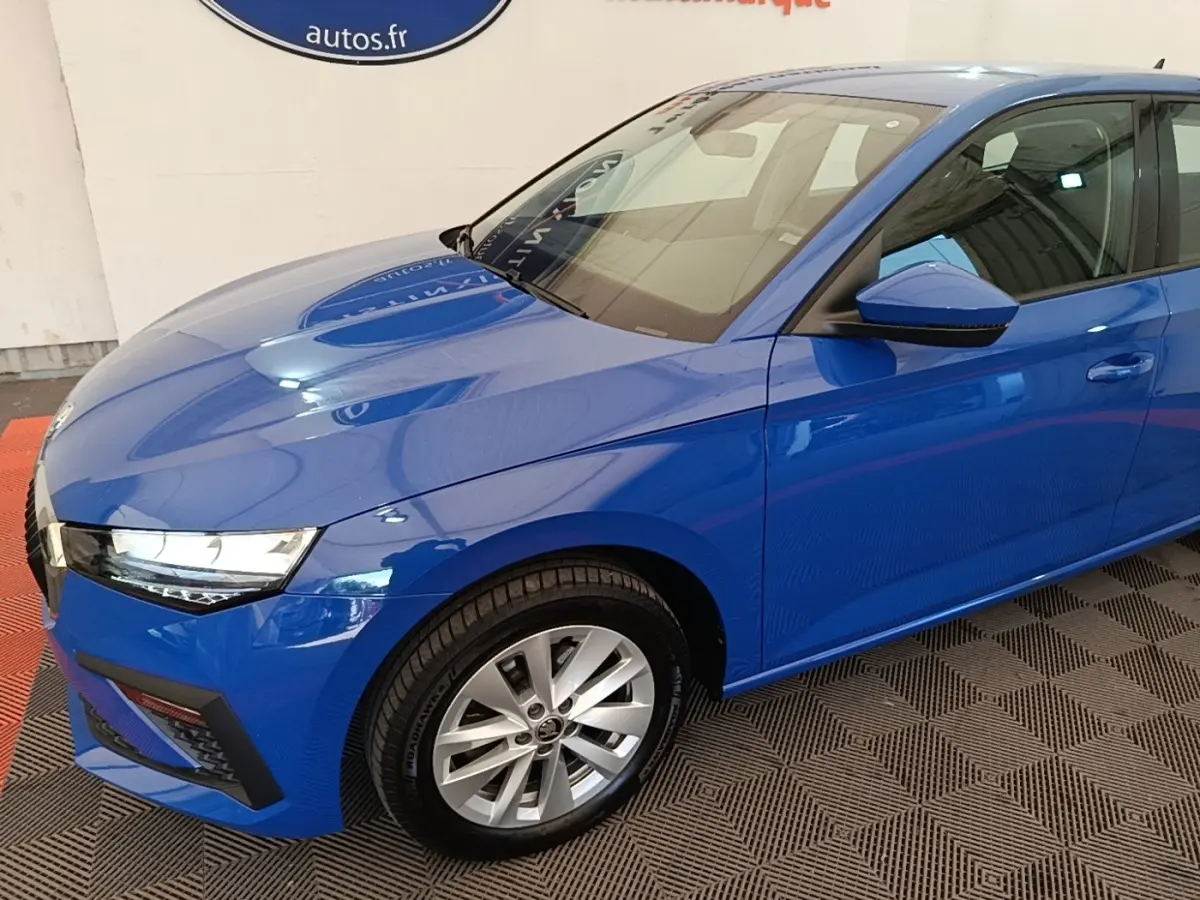 Vue 3/4 avant droit d'une Skoda Scala bleu 2024 avec jantes alliage et rétroviseurs noirs.
