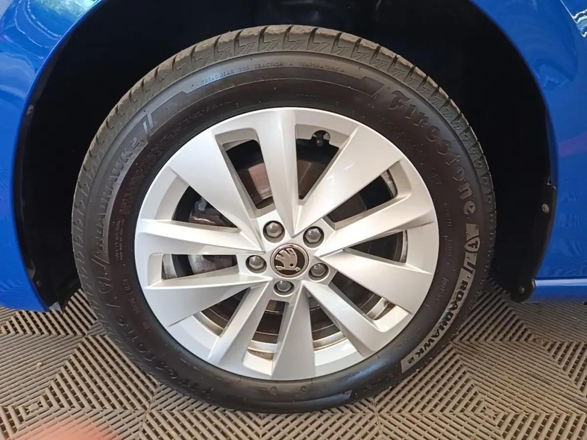 Gros plan sur la roue avant droite d'une Skoda Scala bleu 2024 avec jante alliage argentée et pneu Firestone.
