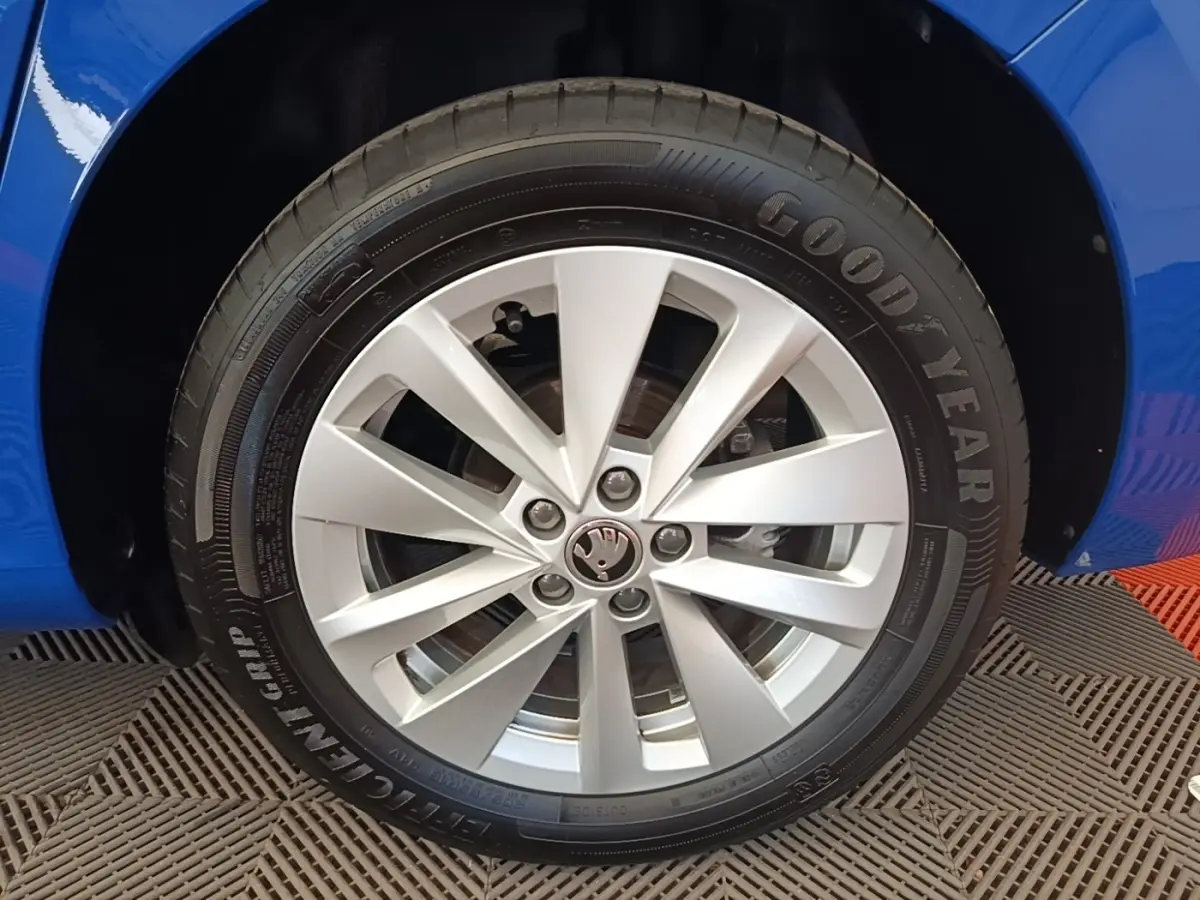 Gros plan sur la roue avant gauche d’une Skoda Scala bleue avec jante alliage argent et pneu Goodyear.