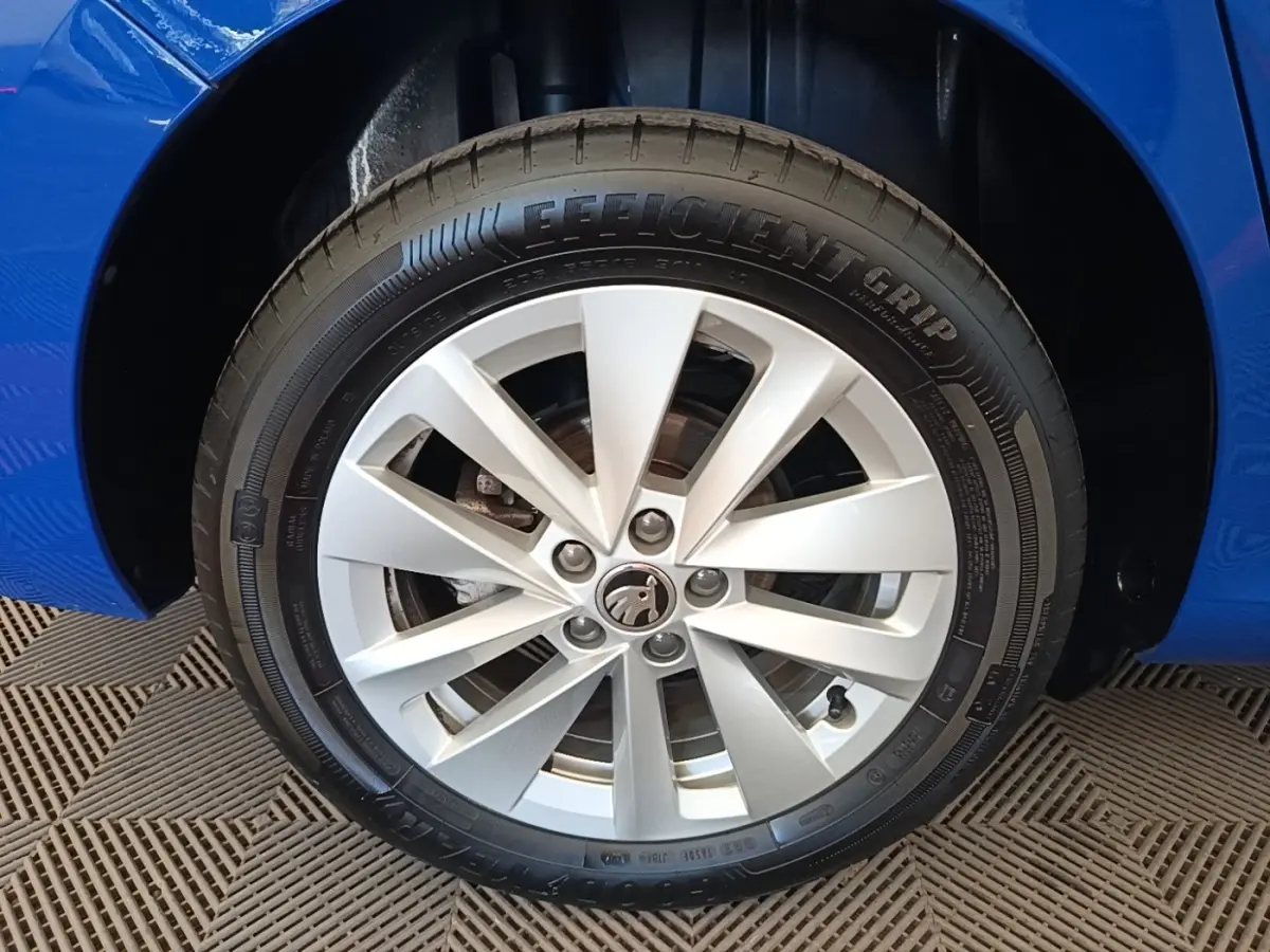 Gros plan sur la roue avant gauche d'une Skoda Scala bleu 2024, mettant en valeur la jante alliage à 10 branches.