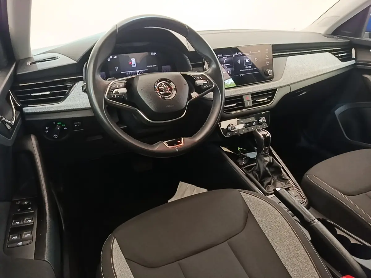Vue intérieure avant du Skoda Scala 2024, volant cuir alu multifonctions et tableau de bord avec écran tactile central.