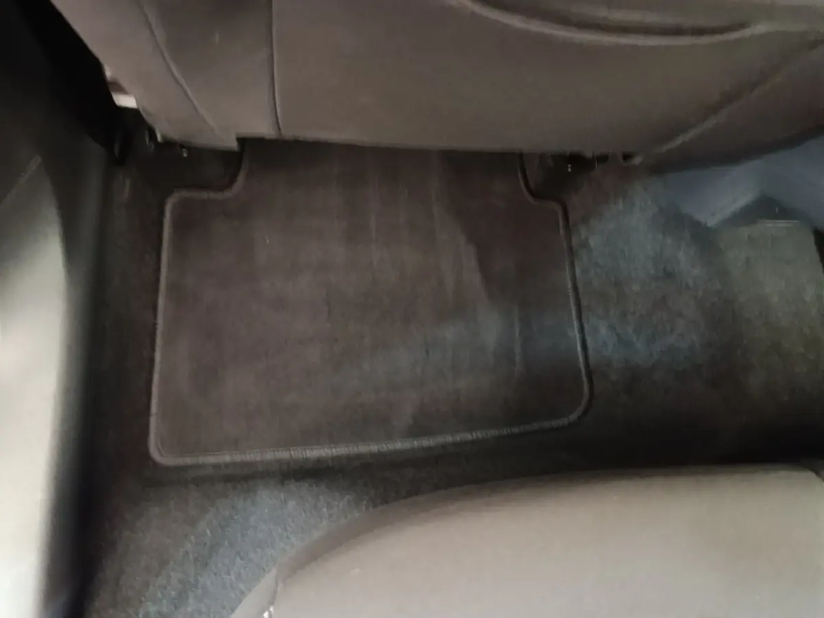 Vue du sol arrière côté droit de la Skoda Scala 2024, tapis de sol noir et siège tissu gris visible.