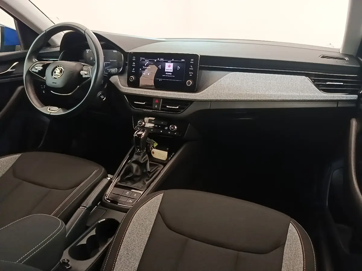 Vue intérieure avant droite de la Skoda Scala 2024, tableau de bord avec écran tactile et volant cuir alu multifonctions.