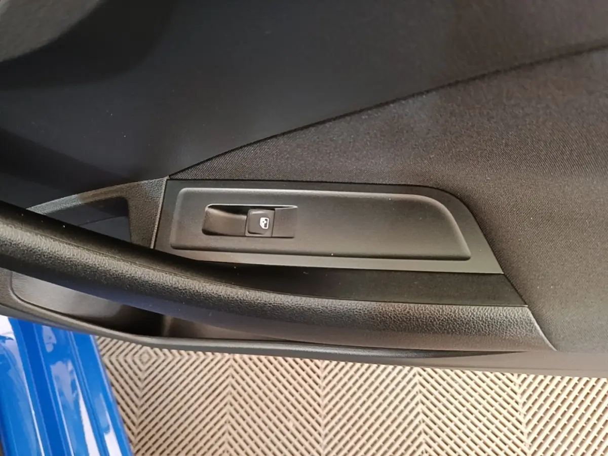 Détail de la commande de verrouillage de porte côté gauche d’une Skoda Scala bleu 2024.