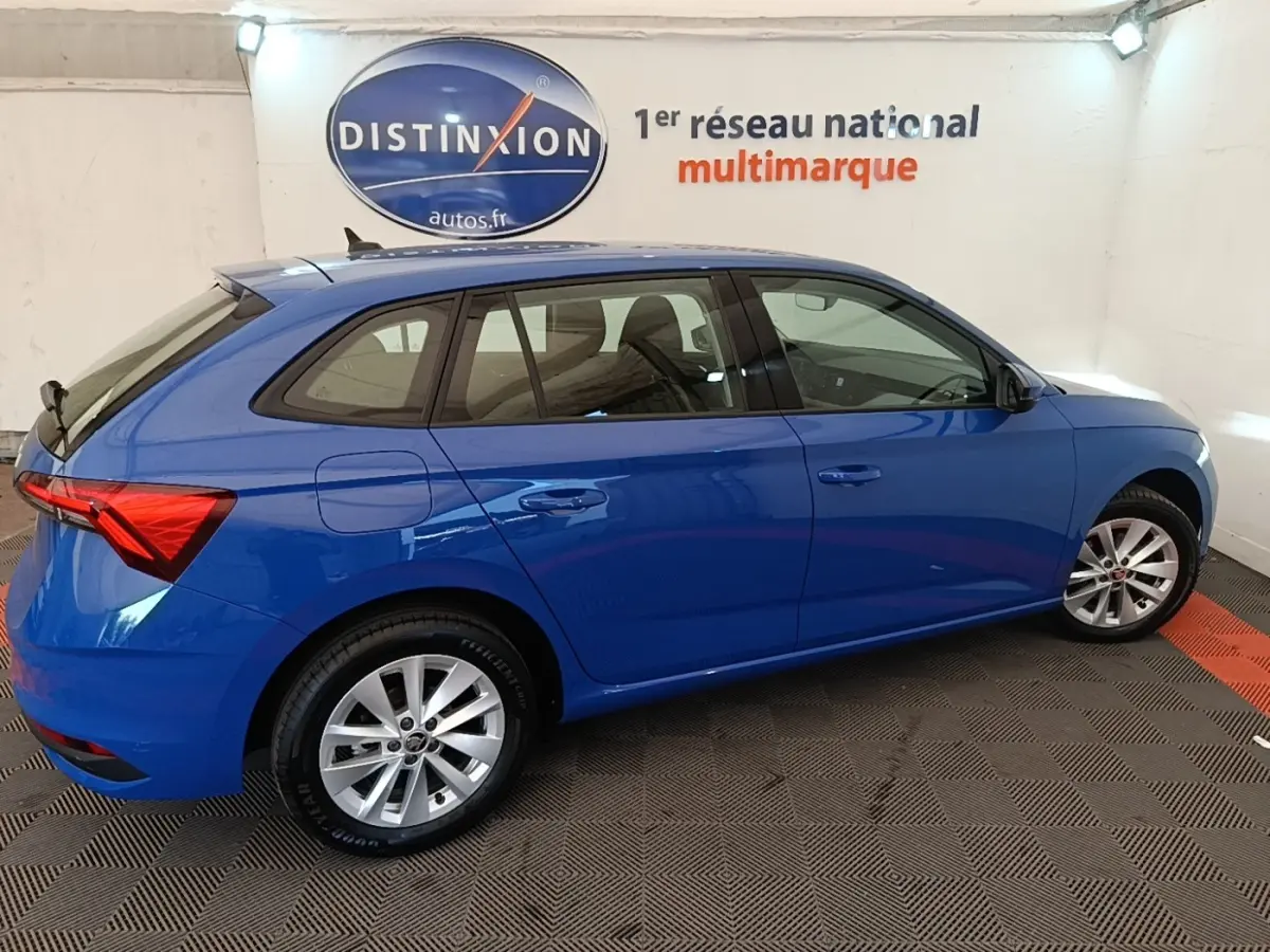 Vue de profil côté droit d'une Skoda Scala 2024 bleu vif, avec jantes alliage et feux arrière LED distinctifs.