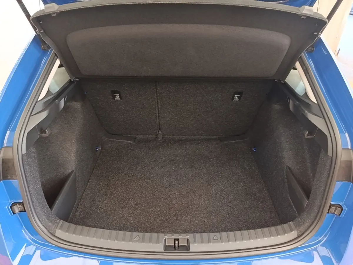 Coffre ouvert vu de l'arrière d'une Skoda Scala 1.5 TSI bleu 2024, montrant l'espace de chargement vide.