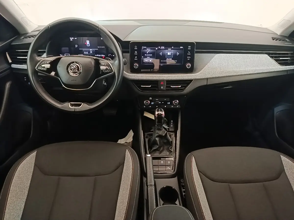 Vue intérieure avant du Skoda Scala 2024, tableau de bord moderne avec écran tactile central et volant multifonctions cuir.