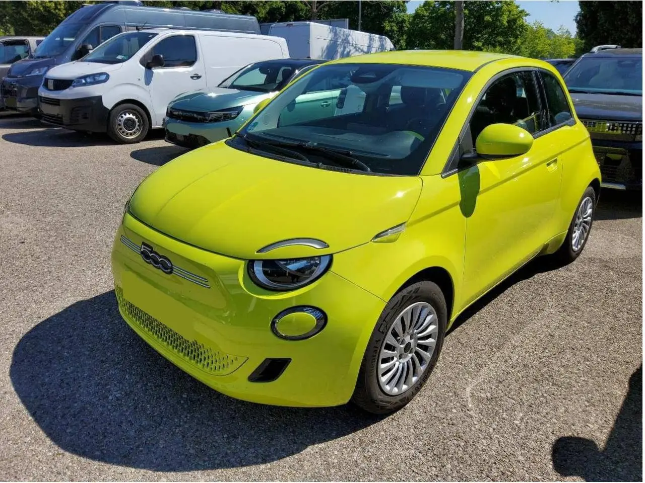 Fiat 500 électrique jaune Acid vue 3/4 avant droit, avec phares ronds et jantes argentées en stationnement.
