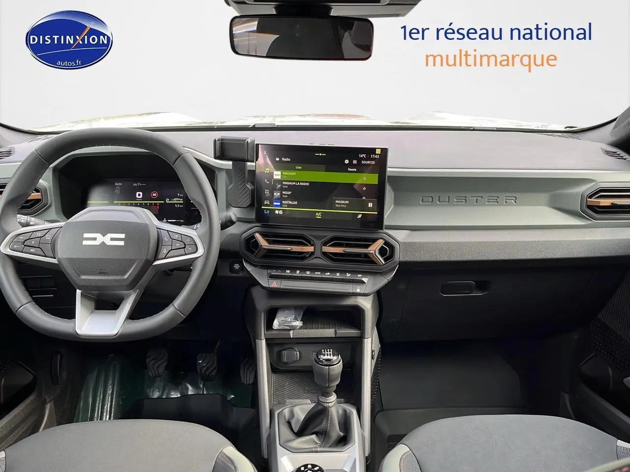 Intérieur avant du Dacia Duster 2025 avec tableau de bord moderne et écran tactile central visible.