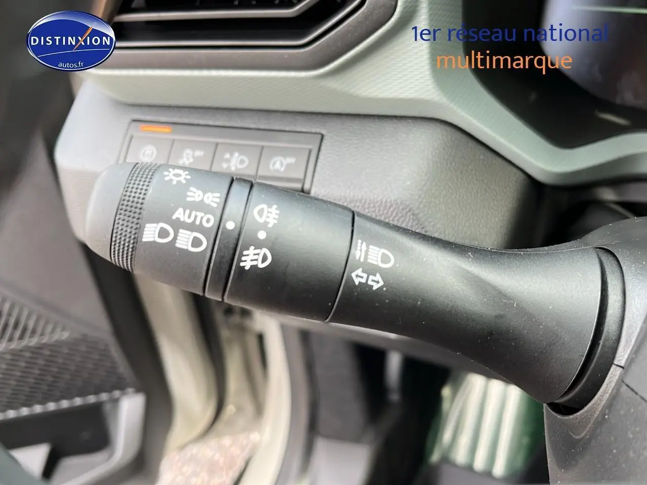 Gros plan sur la commande des phares et clignotants dans l'habitacle du Dacia Duster 2025 couleur Sandstone.