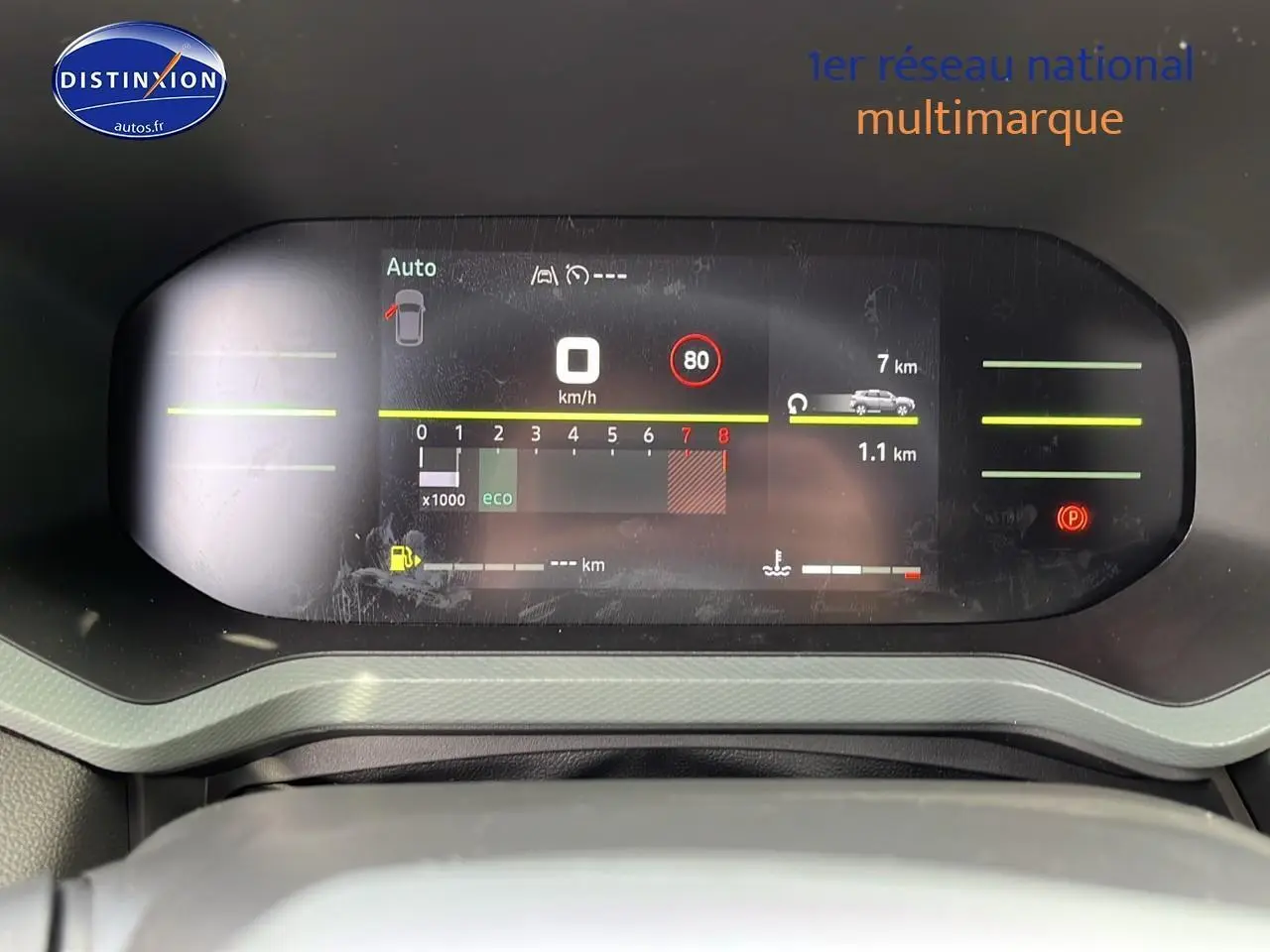 Tableau de bord numérique du Dacia Duster 2025 affichant vitesse, compte-tours et alertes, vue frontale rapprochée.