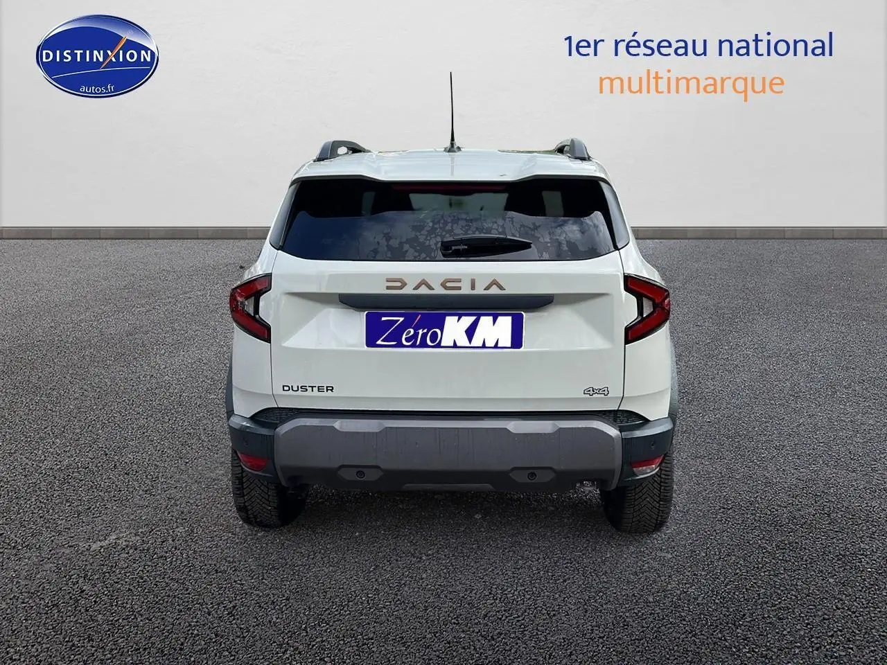 Vue arrière d'un Dacia Duster 2025 couleur Sandstone avec logo et plaques visibles sur un sol goudronné.
