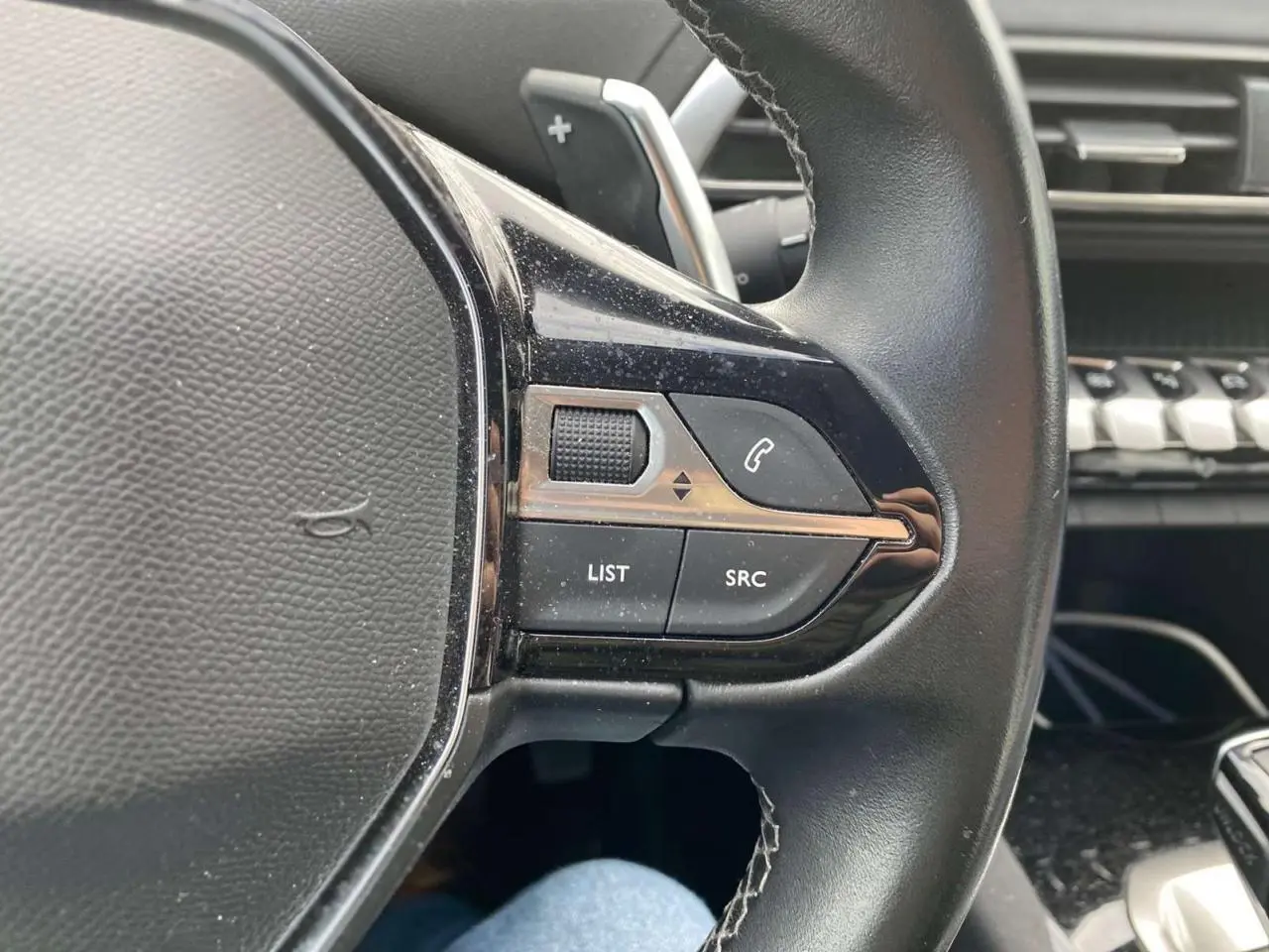 Gros plan sur la partie gauche du volant noir du Peugeot 3008 2019 avec commandes audio et téléphone intégrées.