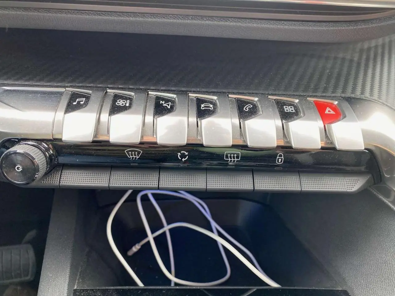 Gros plan sur la rangée de boutons chromés du tableau de bord du Peugeot 3008 noir, version Active 2019.