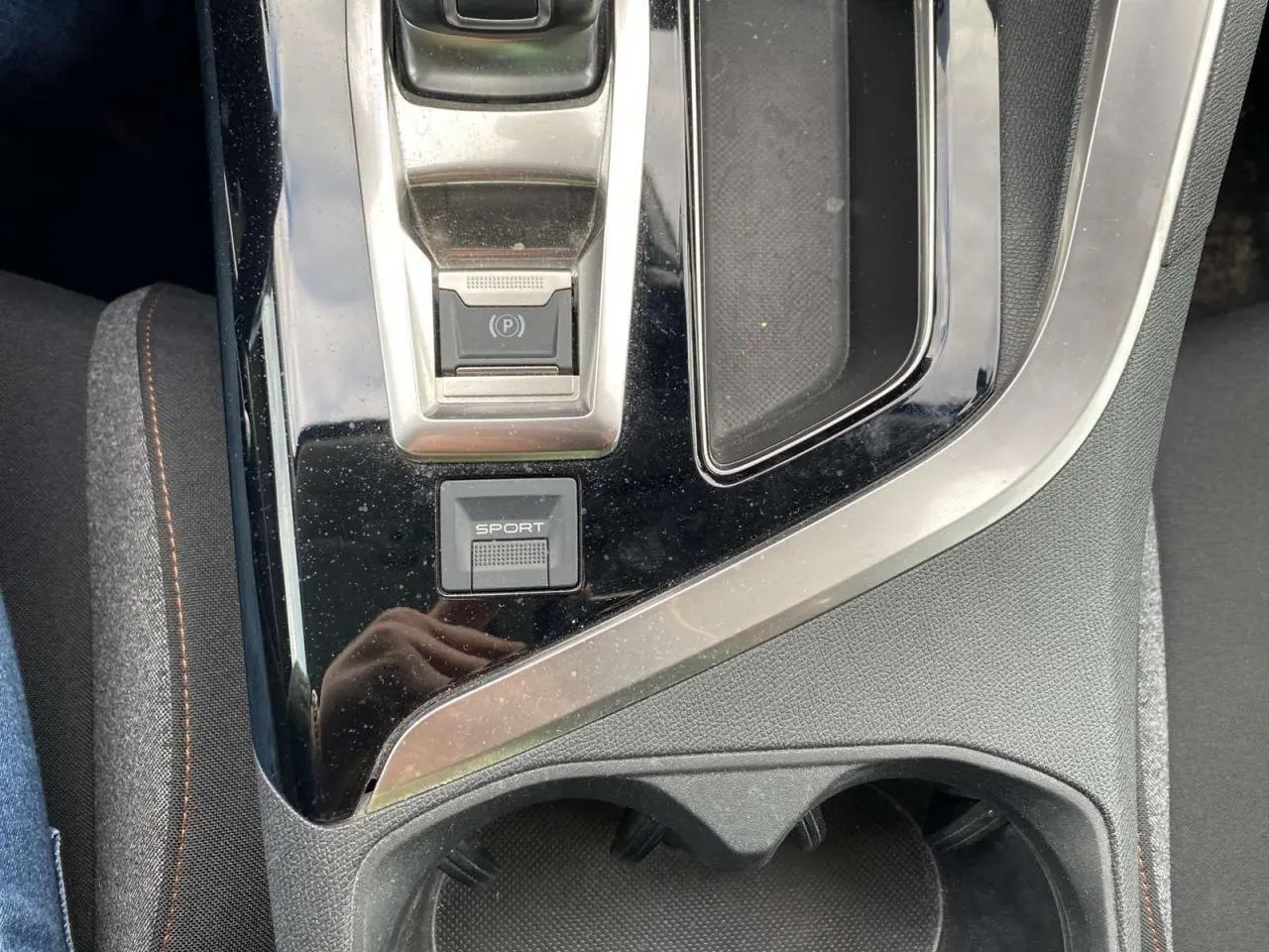 Gros plan sur la console centrale noire du Peugeot 3008 2019 avec bouton sport et frein à main électrique.