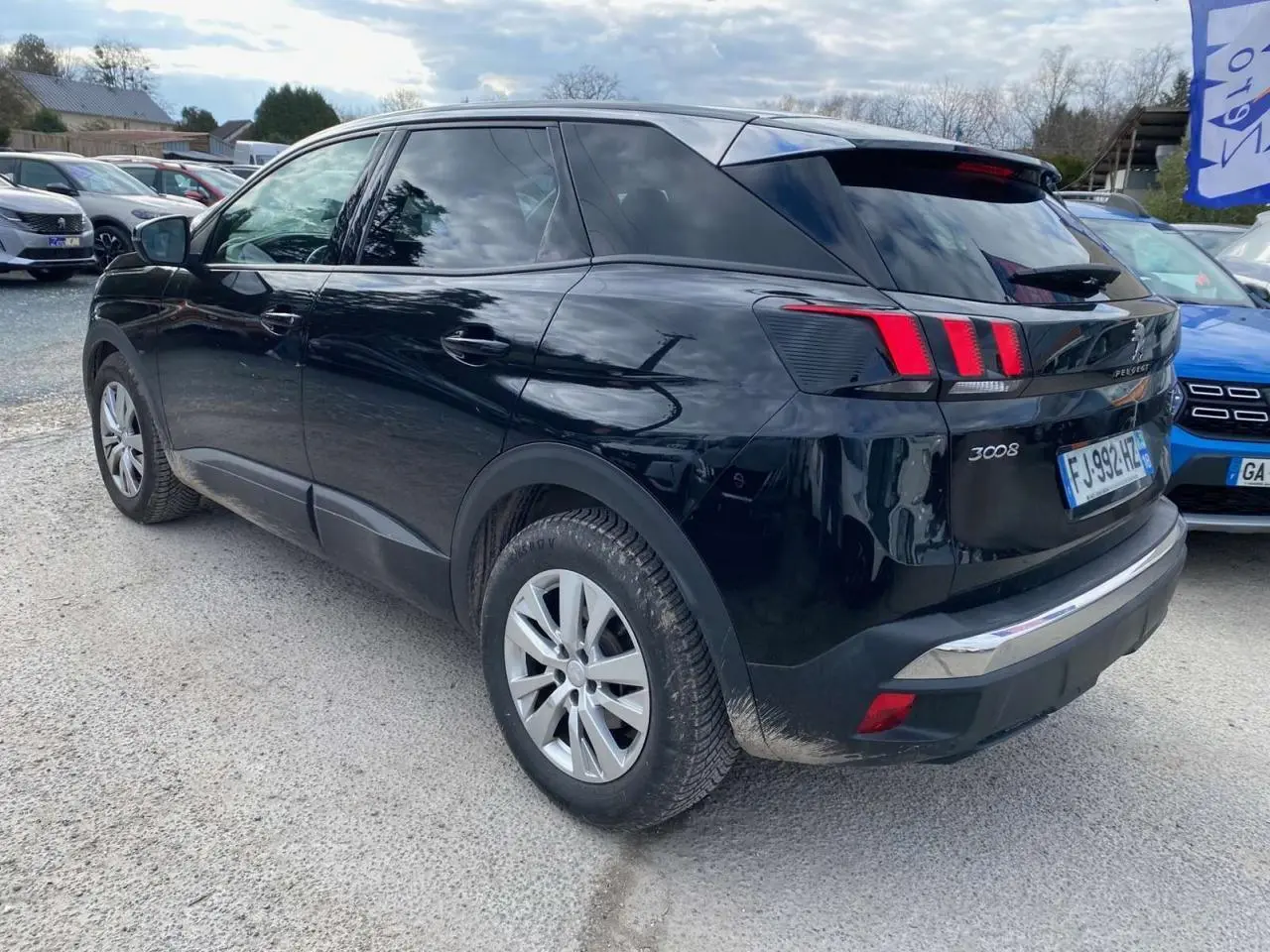 Peugeot 3008 noir vue 3/4 arrière côté gauche, avec feux arrière à trois griffes rouges et jantes argentées.