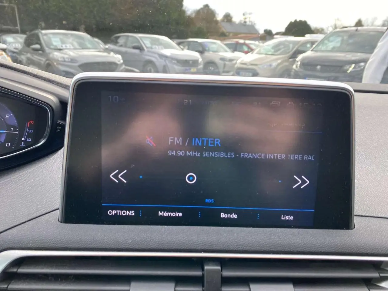 Écran tactile central du tableau de bord du Peugeot 3008 noir, avec affichage radio FM France Inter, vue intérieure avant.