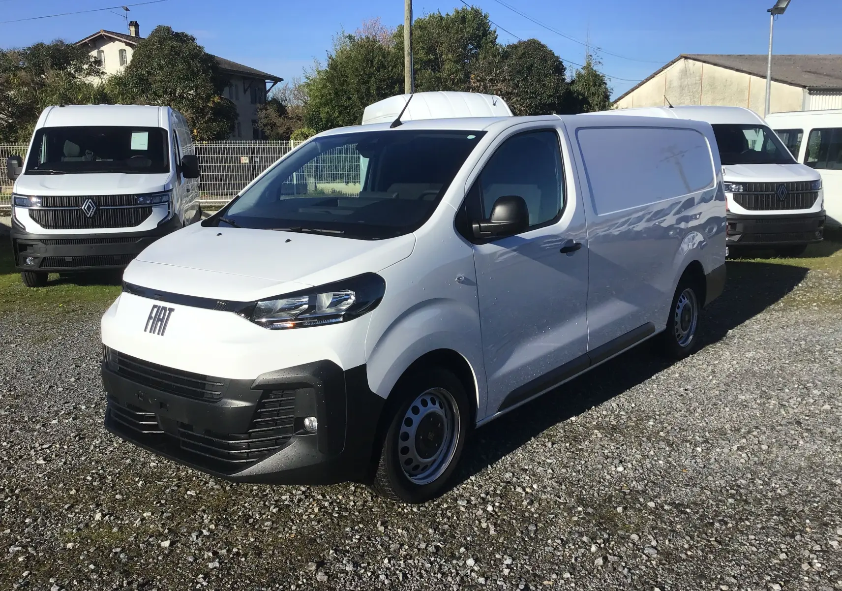 Fourgon FIAT Scudo XL blanc en 3/4 avant droit, avec garde au sol rehaussée et plaque de protection tôlée visible.