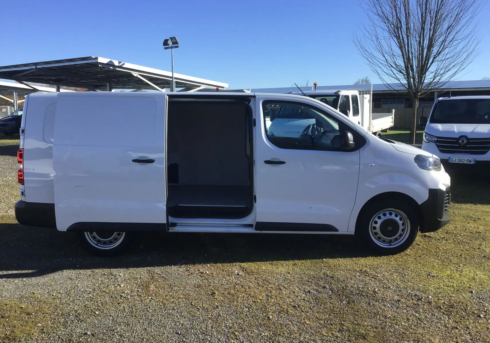Fiat Scudo Fourgon blanc 2024 vu de profil côté droit, porte coulissante ouverte révélant l’espace de chargement.