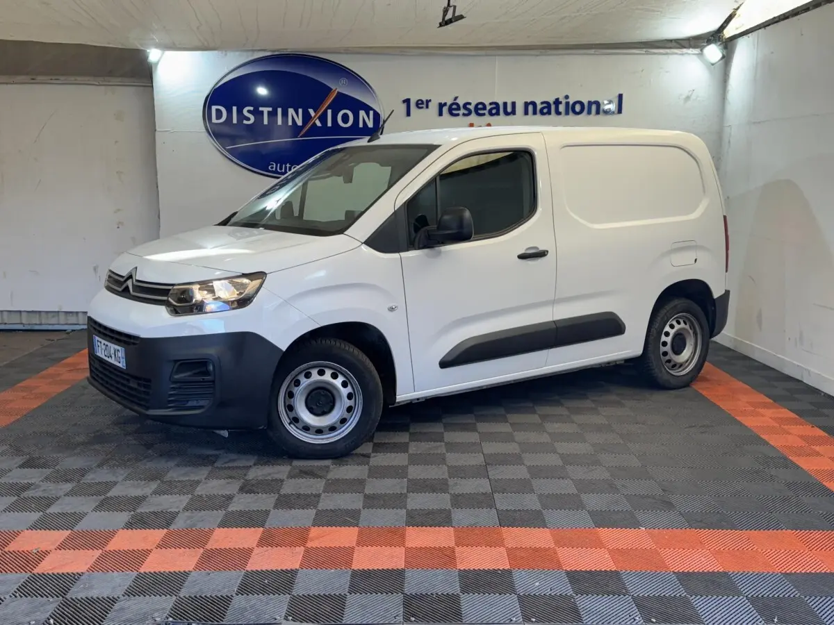 Vue 3/4 avant droit d’un utilitaire Citroën Berlingo blanc avec pare-chocs noir et jantes acier simples.