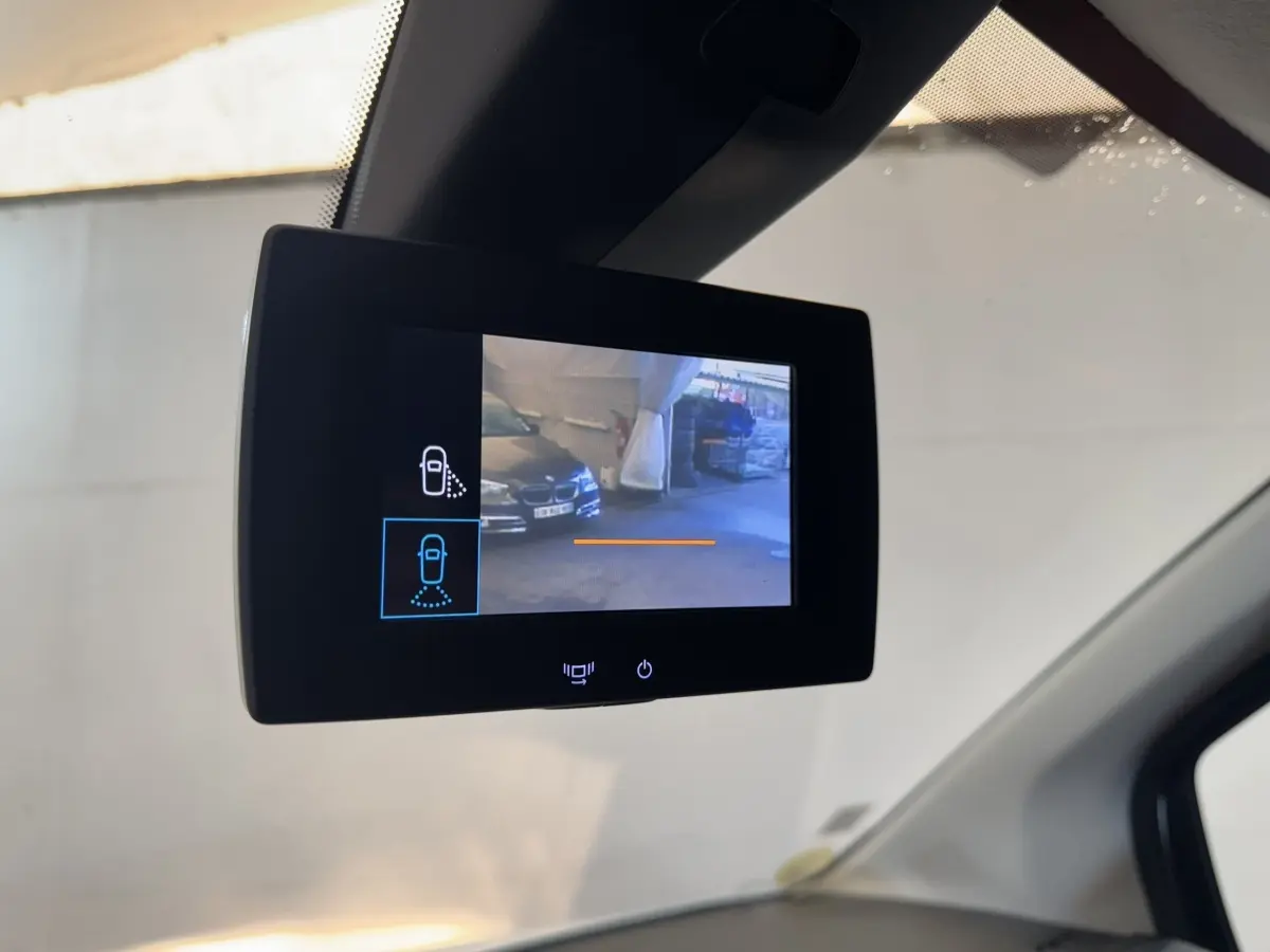 Écran de caméra de rétroviseur intérieur montrant une vue extérieure partielle du véhicule blanc Citroën Berlingo 2020.