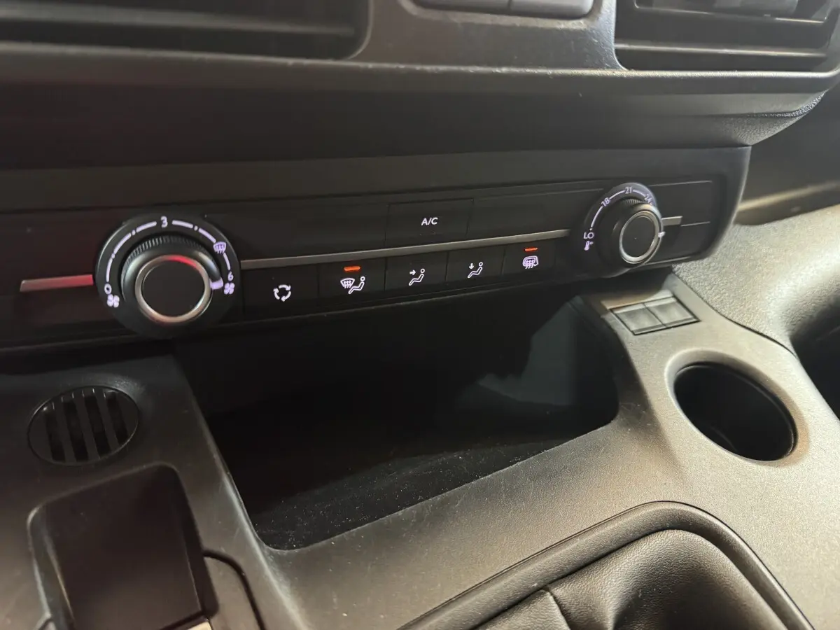Gros plan sur la console centrale noire du Citroën Berlingo 2020, montrant les commandes de climatisation et ventilation.