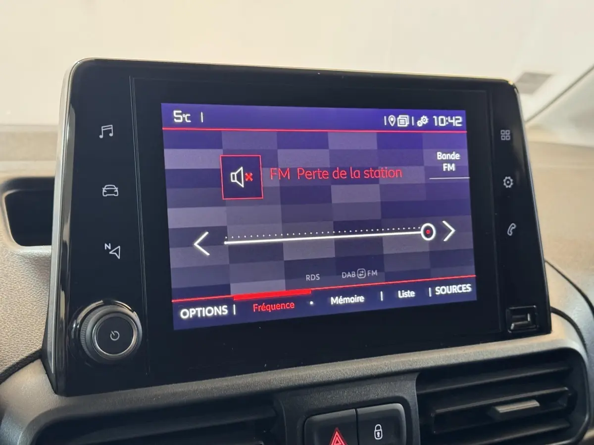 Écran tactile central du tableau de bord du Citroën Berlingo blanc, affichant une perte de station FM.